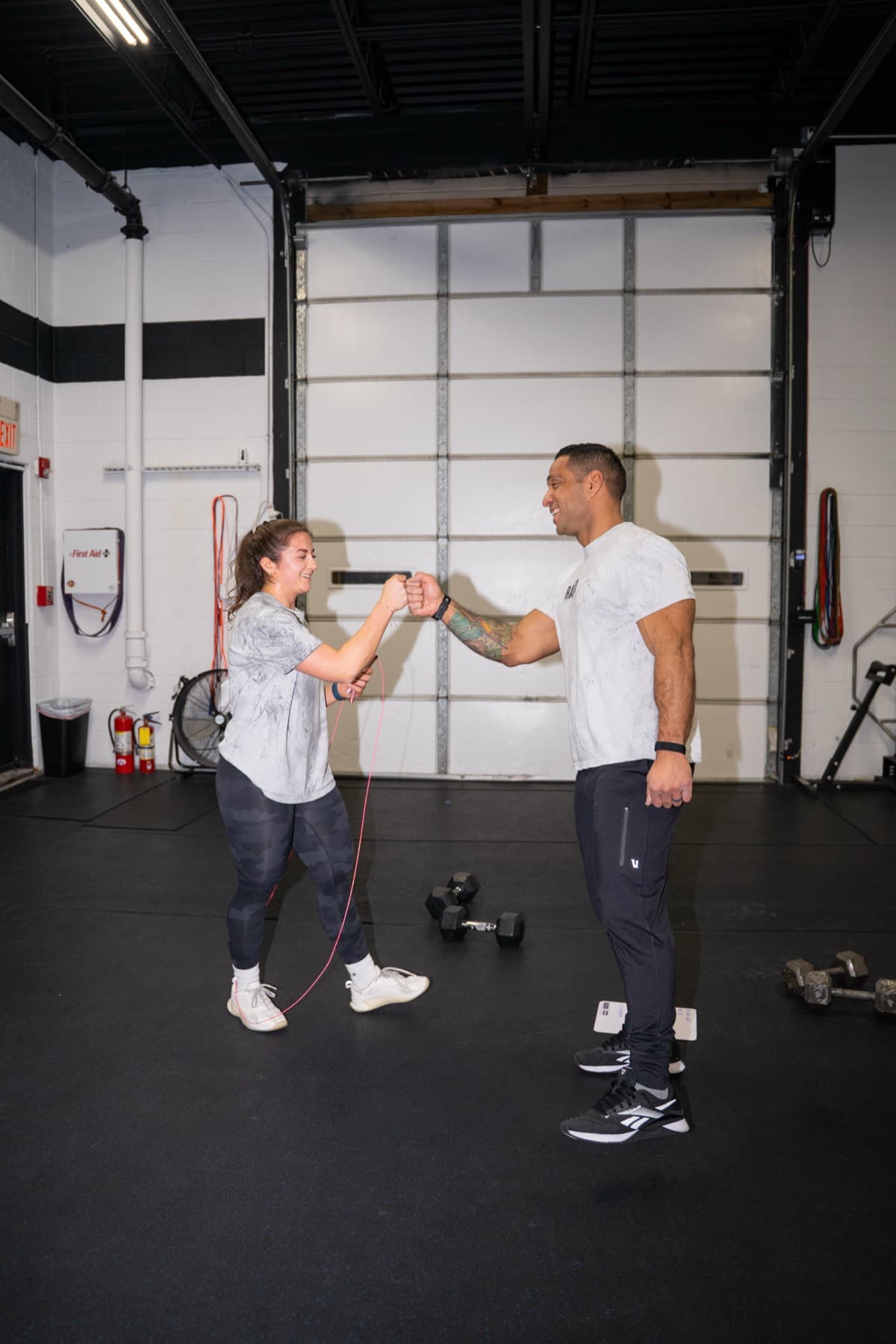 A coach fist bumping a member after a workout